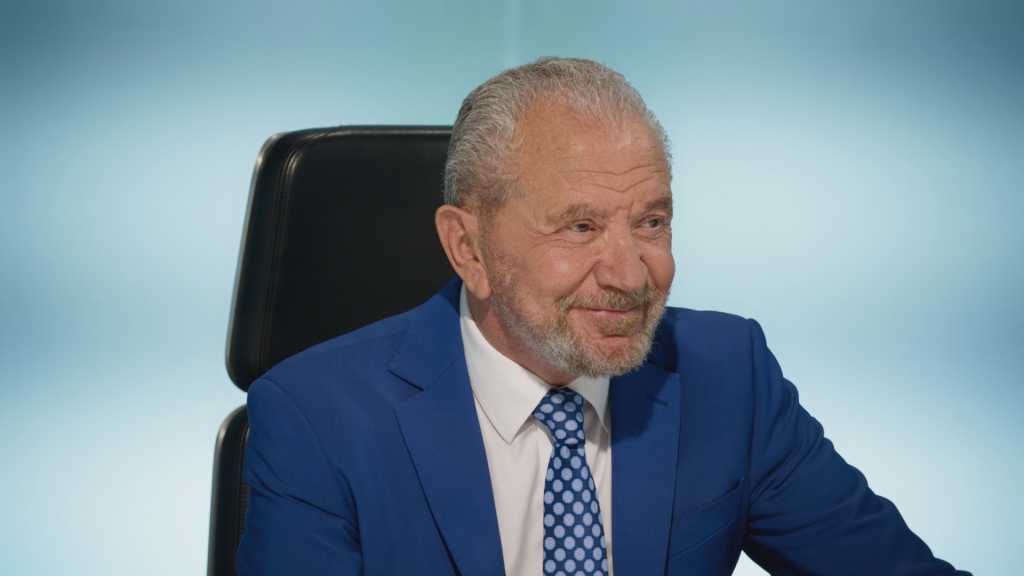 Lord Sugar smiling in the boardroom