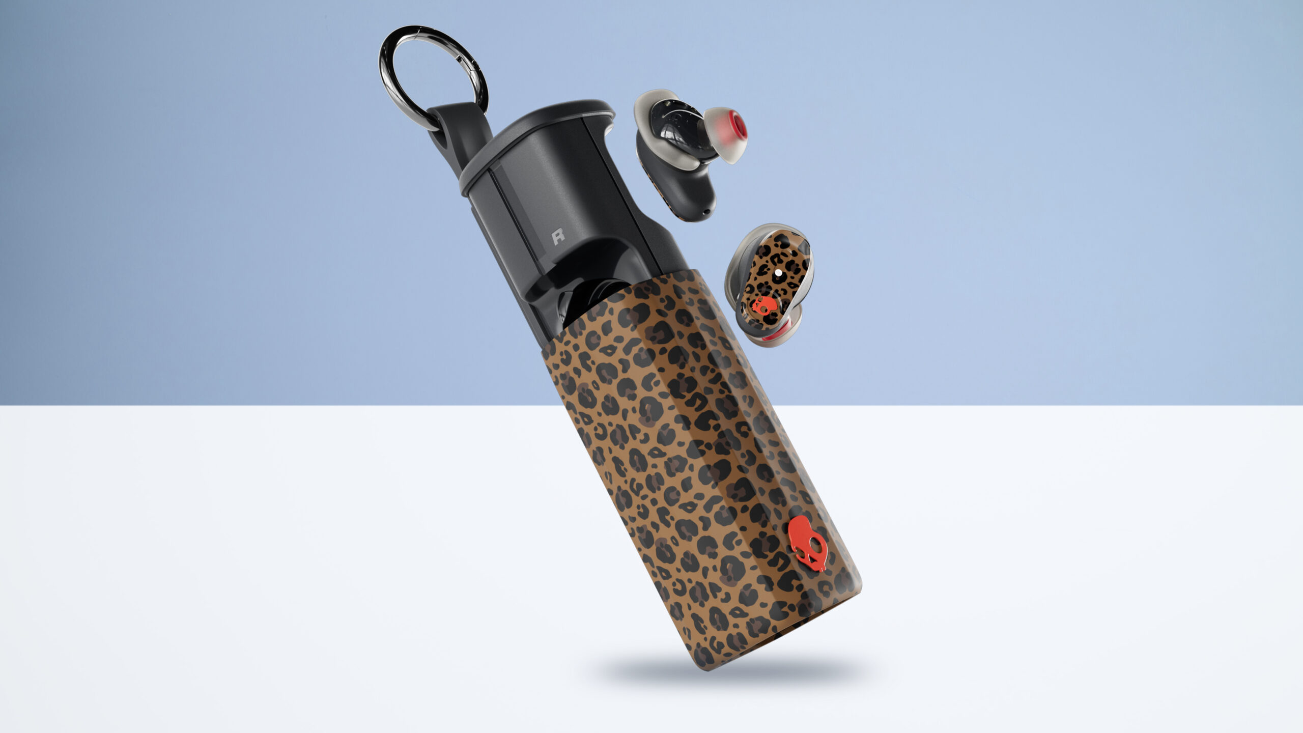 Skullcandy Method 360 ANC in a leopard-print finish, showing the buds outside of the sliding case