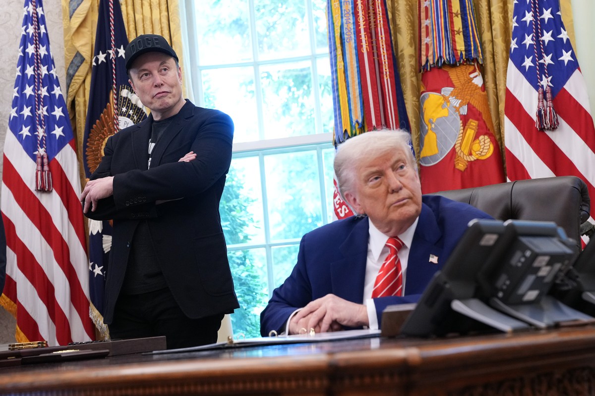 Tesla CEO Elon Musk and U.S. President Donald Trump listen to a question from reporters in the Oval Office of the White House.