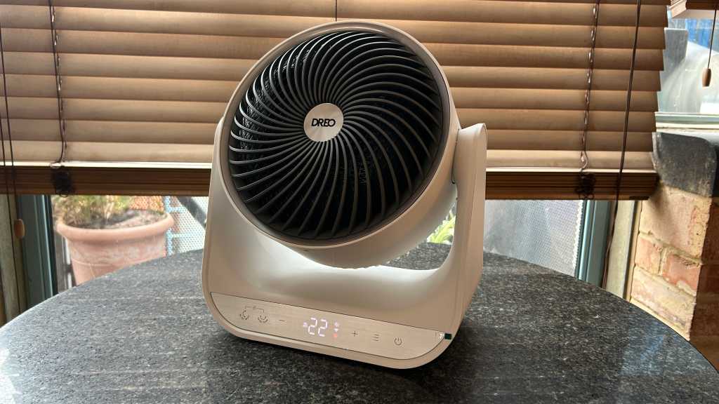 Dreo heater on a table, in front of a window