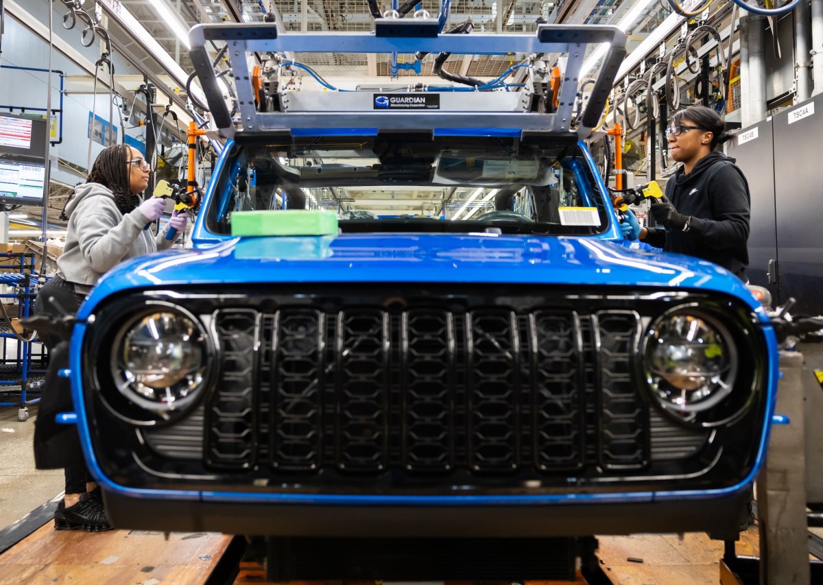 Production operators at the Toledo Assembly Complex secure the windshield of the 2024 Jeep Gladiator into position.